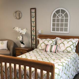 A cozy and inviting bedroom featuring a wooden bed, stylish bedding, and elegant wall decor.