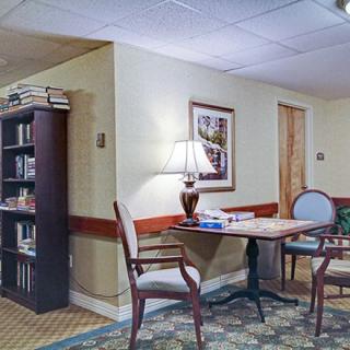 A cozy library corner with a table, chairs, and a bookshelf.