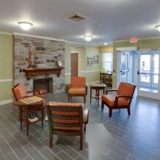 A cozy lobby with comfortable seating around a fireplace.