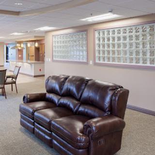 A cozy lounge area featuring a brown leather couch, inviting for relaxation or informal meetings.