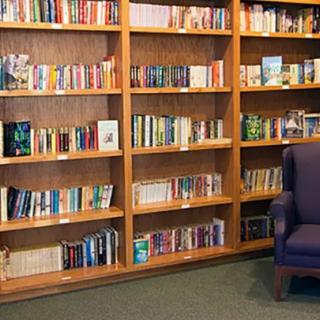 A cozy reading corner with a well-stocked bookshelf and an armchair.