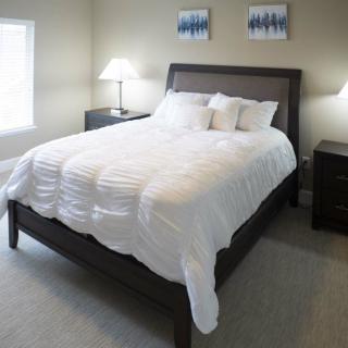 A cozy bedroom with a neatly made bed and two lamps on nightstands.