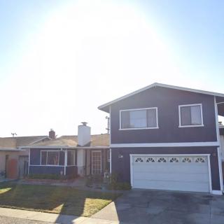 A suburban two-story house with a garage and front yard.