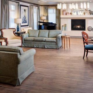 A spacious living room featuring elegant furnishings, a warm fireplace, and a grand piano.
