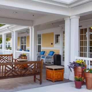 A welcoming porch with comfortable seating and vibrant flowers.