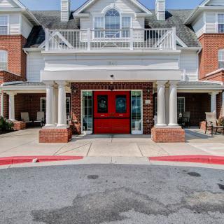 A residential building entrance with red doors and columns.