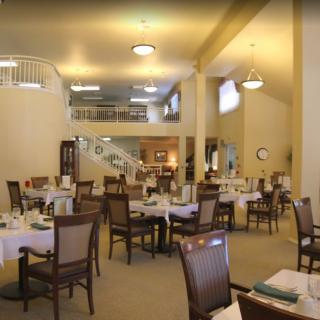 An interior view of a spacious restaurant dining area with neatly arranged tables and chairs.