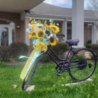 A charming bicycle adorned with a vibrant bouquet of sunflowers, bringing a touch of spring to the outdoor scene.