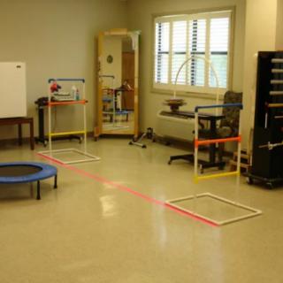 A physical therapy room with exercise equipment and obstacles.