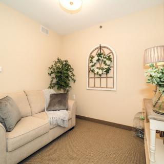 A cozy living room with a beige sofa, green plants, and elegant decor.