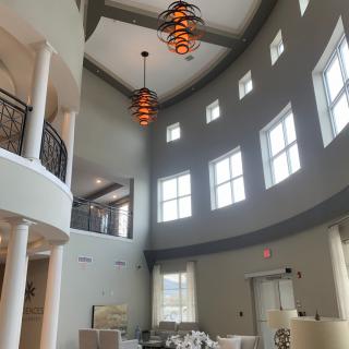 A spacious modern lobby featuring large windows and elegant chandeliers.