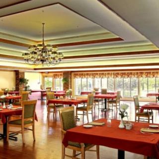 An elegant restaurant dining area with red tablecloths and a chandelier.