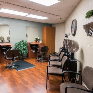 A well-lit hair salon interior with chairs and mirrors.