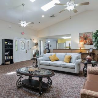 A spacious and well-lit living room with comfortable seating and elegant decor.
