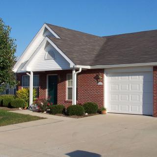A suburban brick house with a garage and driveway.