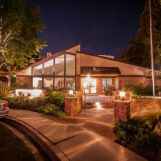 A modern house beautifully illuminated at night, showcasing its unique architectural design.