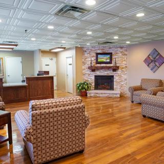 A welcoming lobby area featuring comfortable seating, a wooden floor, and a fireplace.