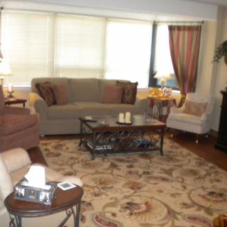 A cozy living room with a sofa, coffee table, and patterned rug.