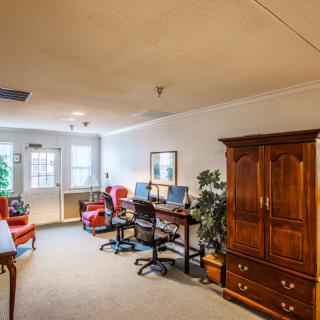 A cozy office space with two desks, computers, and comfortable chairs.