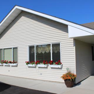 A residential house exterior with flower boxes and a clear blue sky.