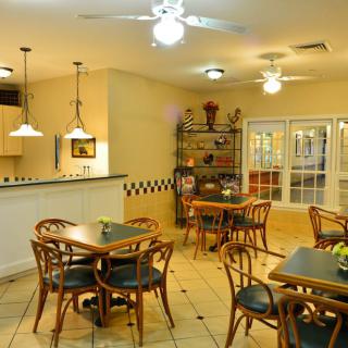 A cozy cafe interior with tables, chairs, and warm lighting.
