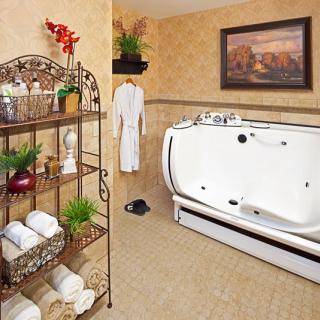 A well-decorated bathroom featuring a modern bathtub, neatly arranged towels on shelves, and lush green plants for a fresh ambiance.