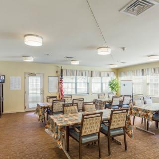 A well-lit meeting room with tables and chairs arranged for a gathering.