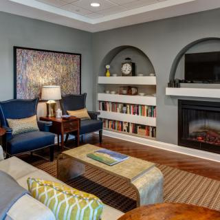 A cozy living room with a fireplace, bookshelves, and comfortable seating.