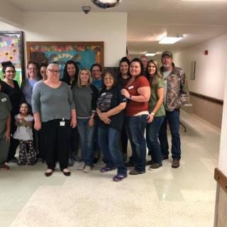 A cheerful gathering of friends and colleagues smiling together in a hallway.