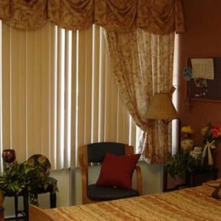 A cozy bedroom with elegant curtains and a comfortable chair by the window.