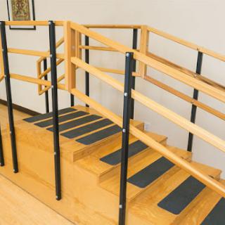 A set of stairs equipped with handrails and safety markings, designed for accessibility.