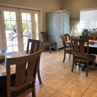 A cozy dining area with wooden furniture and large windows allowing natural light to fill the space.
