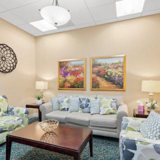 A cozy living room with comfortable sofas, decorative pillows, and colorful artwork on the walls.