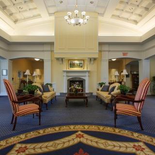 A luxurious lobby with elegant furnishings and a central fireplace.