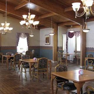 A spacious dining room with elegant chandeliers and wooden decor.