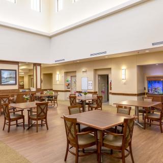 A spacious and well-lit dining area with multiple tables and chairs arranged neatly.