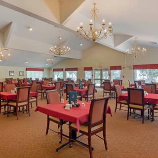 A spacious dining room with elegantly set tables and chandeliers.
