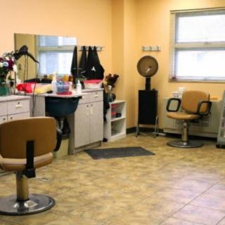 An interior view of a hair salon with chairs and mirrors.