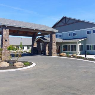 A modern residential building with a covered entrance and driveway.