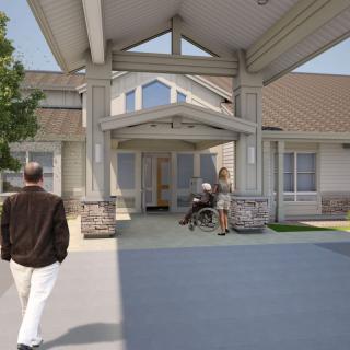 A modern building entrance with a person in a wheelchair and another person walking nearby.