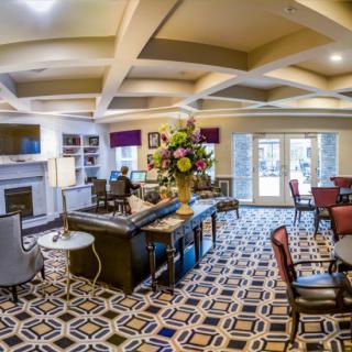 A modern and well-decorated living room with contemporary furniture and vibrant carpeting.