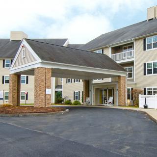 A residential building with a covered entrance and driveway.