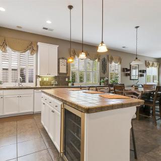 A spacious kitchen featuring a large island with pendant lighting and an open dining area.