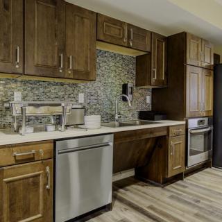 A modern kitchen interior featuring wooden cabinets, a dishwasher, and an oven.