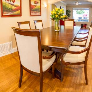 A well-designed dining room with a wooden table and chairs, complemented by floral decor and artwork on the walls.