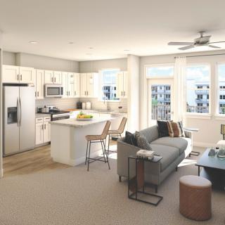 A modern, open-concept living room and kitchen area with abundant natural light in a contemporary apartment.