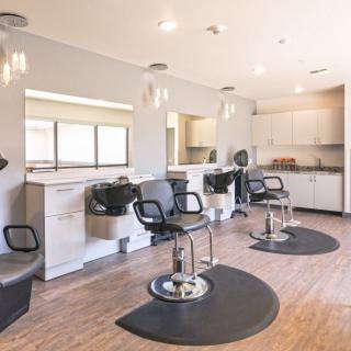 A modern hair salon interior with styling stations and chairs.