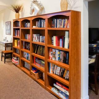 A well-organized wooden bookshelf filled with various books, adding a cozy touch to the living room.