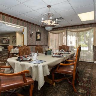 A well-appointed dining room with a wooden table and chairs, adorned by a chandelier.