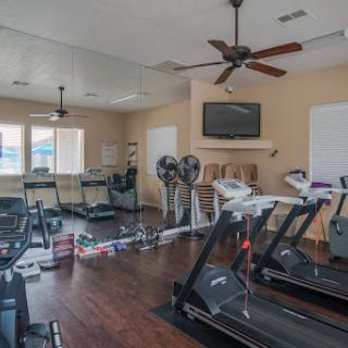 A well-equipped gym featuring multiple treadmills and a spacious workout area.
